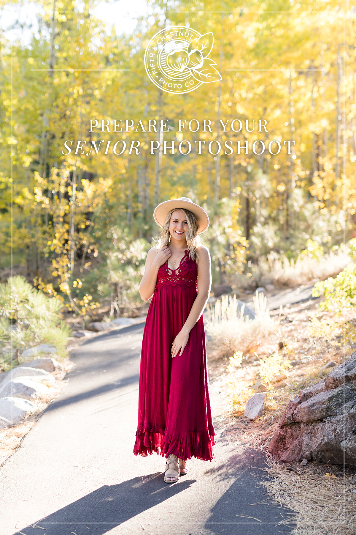 Reno high school senior girl in red dress with wide brimmed hat walking down a paved path lined with yellow aspen trees in the fall at galena creek park for reno senior photos by Fifth and Chestnut Photo Co.