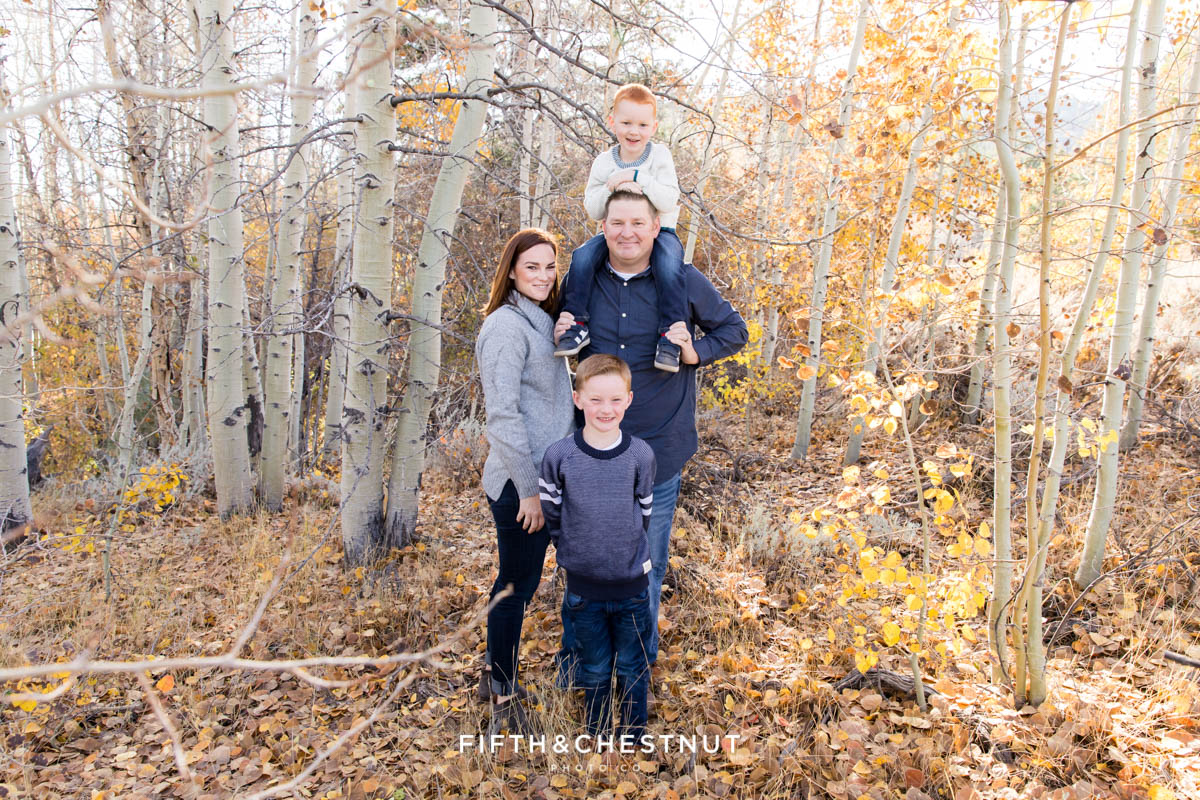 Family standing together lovingly for their Thomas Creek Portraits in front of aspen trees during the fall.