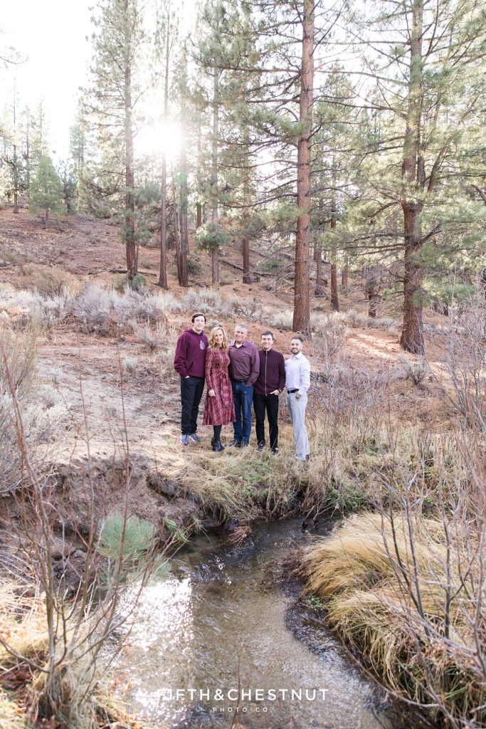 a family of 5 huddles together above a babbling brook for their fall mountain family portraits