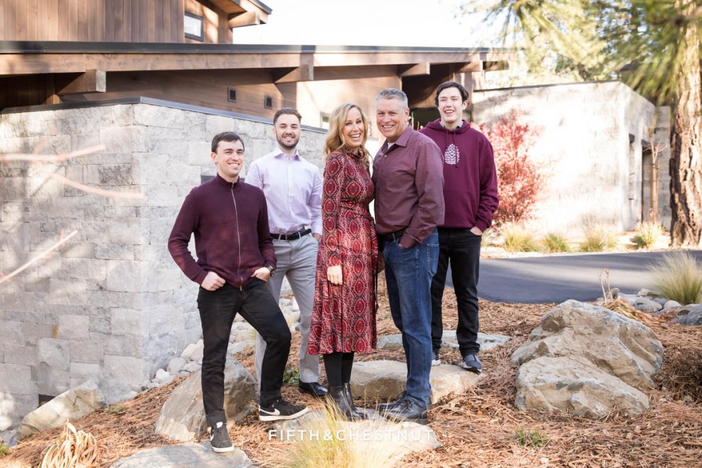 a family poses in front of their lovely tahoe mountain home