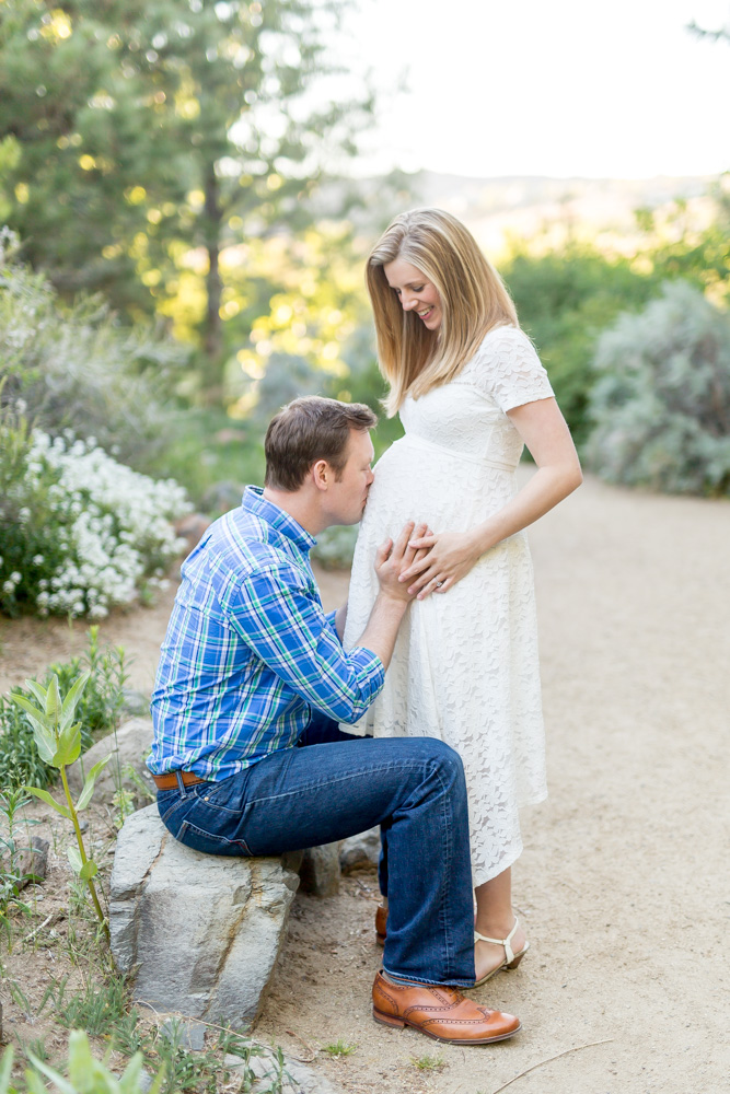 Father to be kisses his wife's pregnant tummy for a portrait by Reno Maternity Photographer