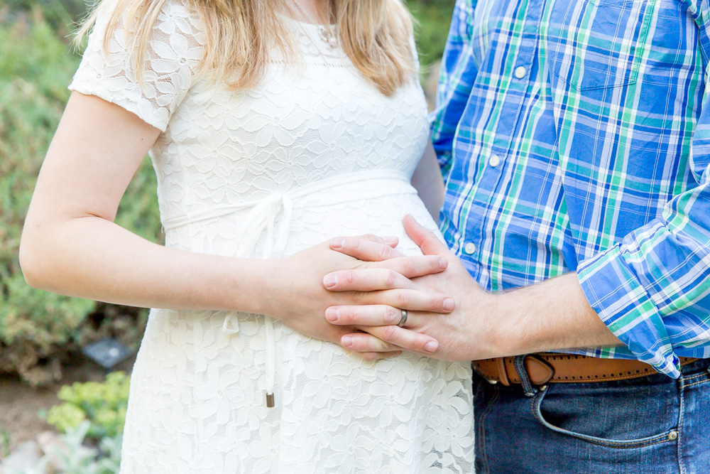 Father and mom to be hold on to her pregnant tummy