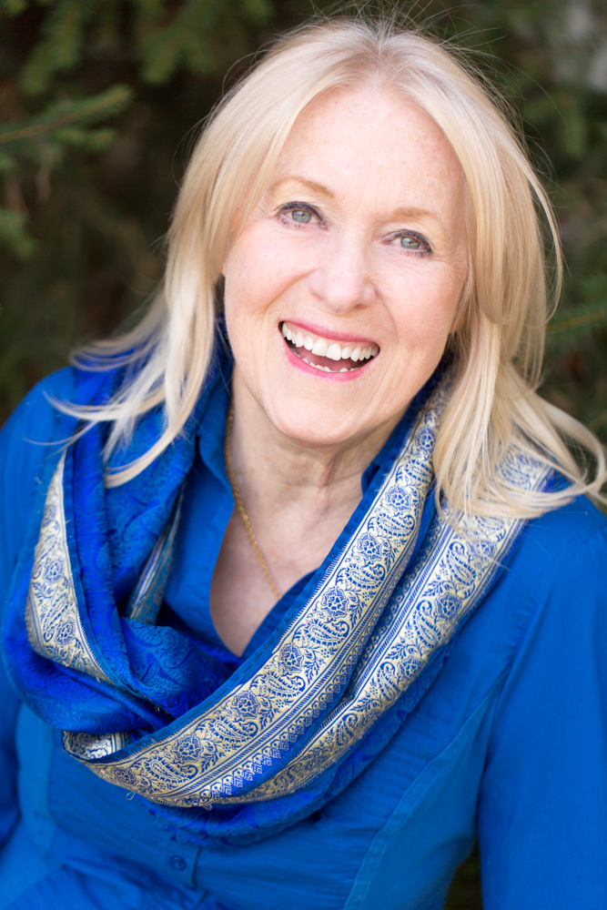 Portrait of published Lake Tahoe author laughing and wearing a blue shirt and blue scarf by Reno Headshot Photographer