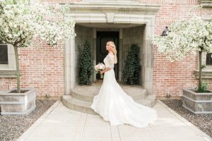 Portrait of a beautiful bride in a long wedding gown on a porch filled with cherry blossom trees at a private estate for a country french inspired wedding by Lake Tahoe Wedding Photographer