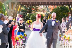 Bride and groom walk down the aisle through bubbles as husband and wife at the grove