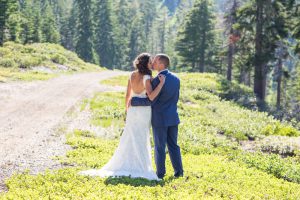Bride and groom kiss as the sun gleams behind them on top of Homewood for their West shore Tahoe wedding