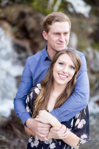 Engaged couple embracing in front of spring waterfall for an engagement portrait by Lake Tahoe Wedding Photographer