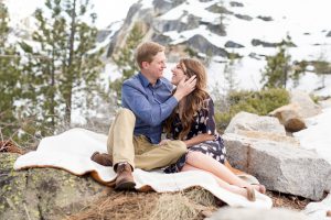 Engaged couple sitting on a cozy blanket looking into each other's eyes for an engagement portrait by Lake Tahoe Wedding Photographer