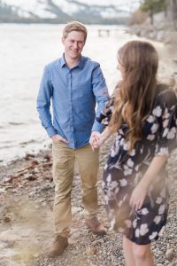 Bride to be walks away from groom to be while holding his hand and smiling during an engagement portrait by Lake Tahoe Wedding Photographer