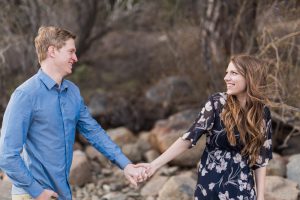 Bride and groom to be smile at one another while on the shore of Donner Lake for their engagement portrait by Lake Tahoe Wedding Photographer