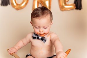 Boy playing with spoons and spaghetti during his One Year Spaghetti Smash portrait session by Reno Baby Photographer