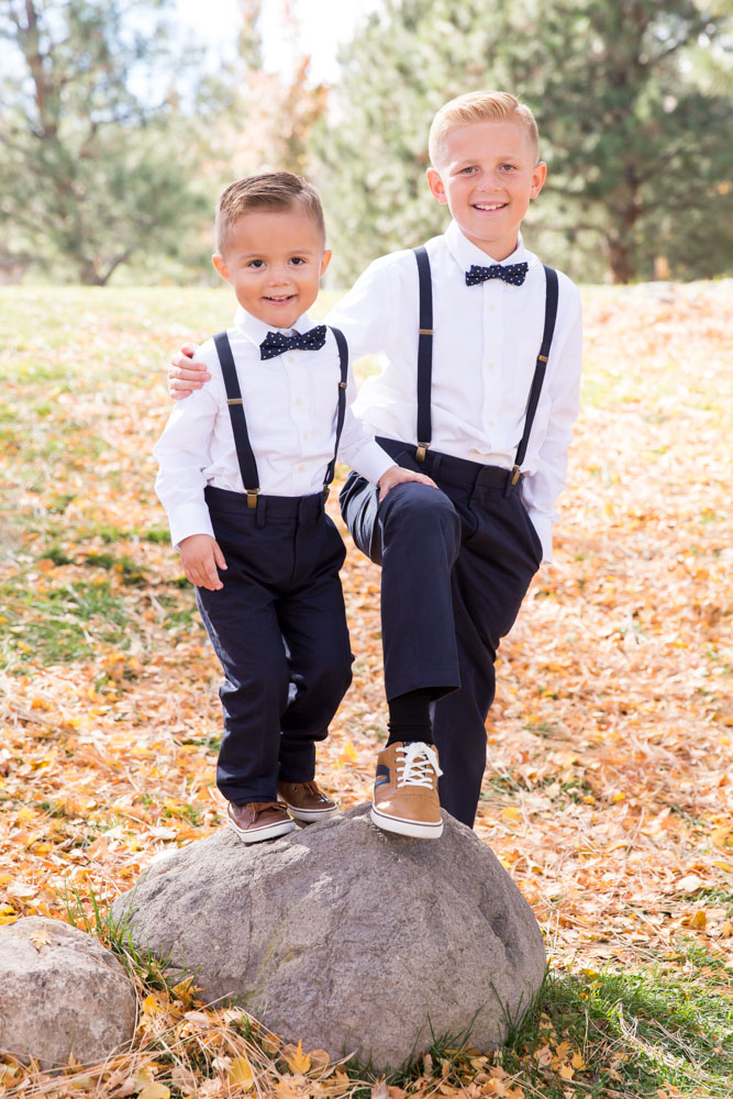 Brothers standing together on a rock wearing suspenders and bowties for a family portrait by Reno Family Photographer