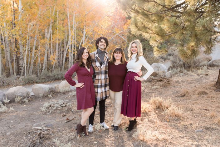 A mom and her three adult children pose for a photo with golden aspens and the sun shining behind them for portraits by Reno Family Photographer