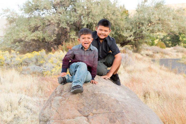 Two elementary school aged boys sit on rock at Mayberry Park for Reno Family Portraits by Reno Family Photographer