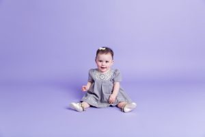 Sitter session portrait of girl on purple background by Reno Baby Photographer