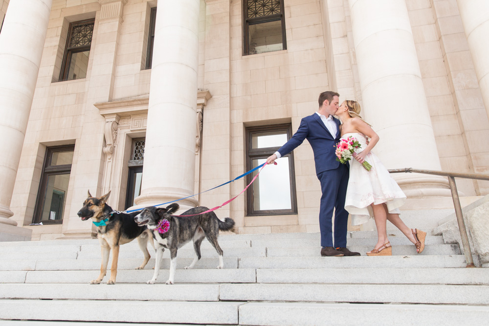 Elopement couple poses with dogs in front of the old Reno City Courthouse for photos by Reno Wedding Photographer