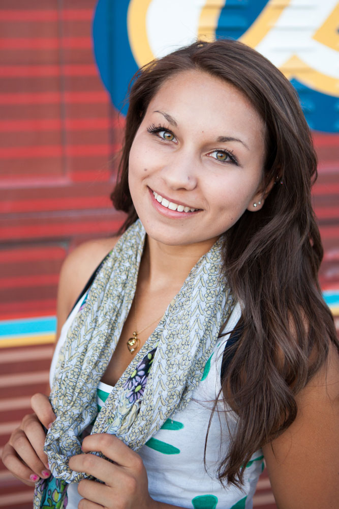 Cute summer senior portraits by Reno Senior Photographer at the Freighthouse District in Reno with a girl wearing a floral scarf and a white and green tank top.