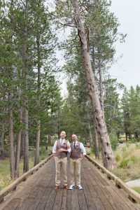 Grooms stand together on bridge at PJ's at Gray's for their Truckee Wedding