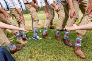 wedding party showing off blue socks that say "carpe the fuck out of this diem"