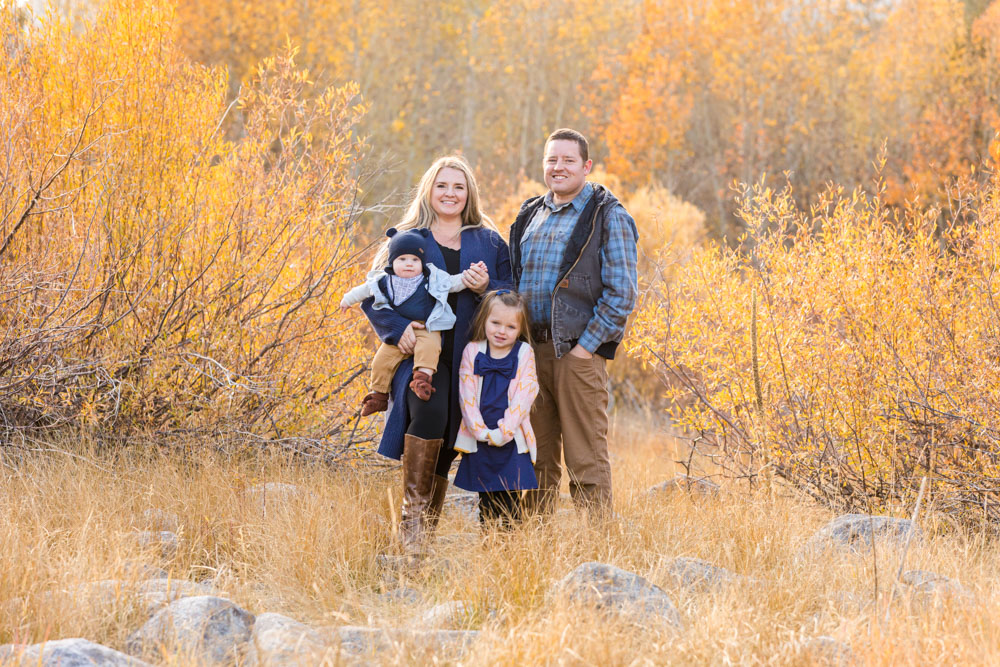 Family of four stands in a golden field in Hope Valley, CA for their family portraits in peak fall season with Hope Valley Family Photographer
