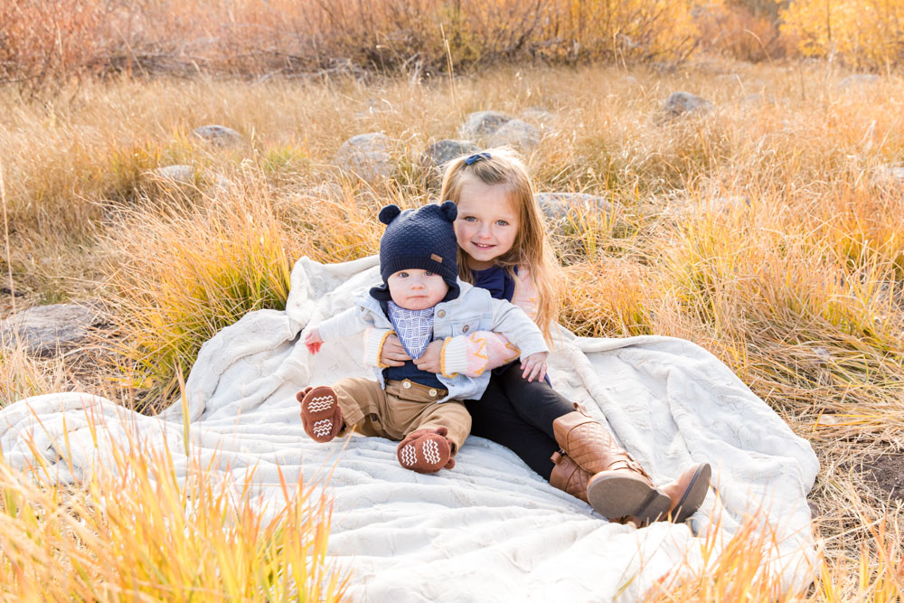 A big sister cuddles her baby brother on a furry blanket in Hope Valley for their Hope Valley Family Photography