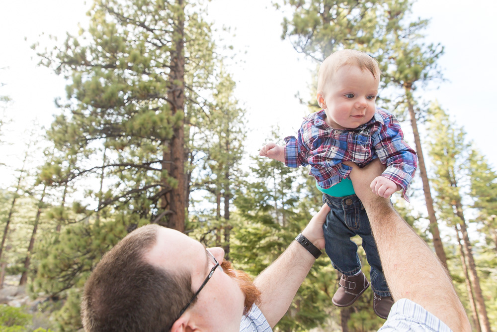 dad holds baby boy in the air for his family photos at galena creek park by reno family photographer