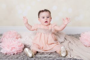 Baby Girl catching bubbles and wearing a glittery pink dress for portraits by Reno Baby Photographer Fifth and Chestnut