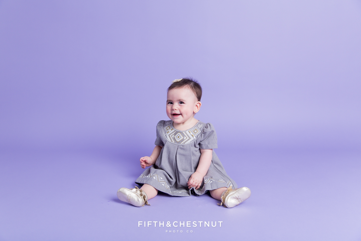 Baby Girl wearing a gray and gold dress for portraits by Reno Baby Photographer Fifth and Chestnut