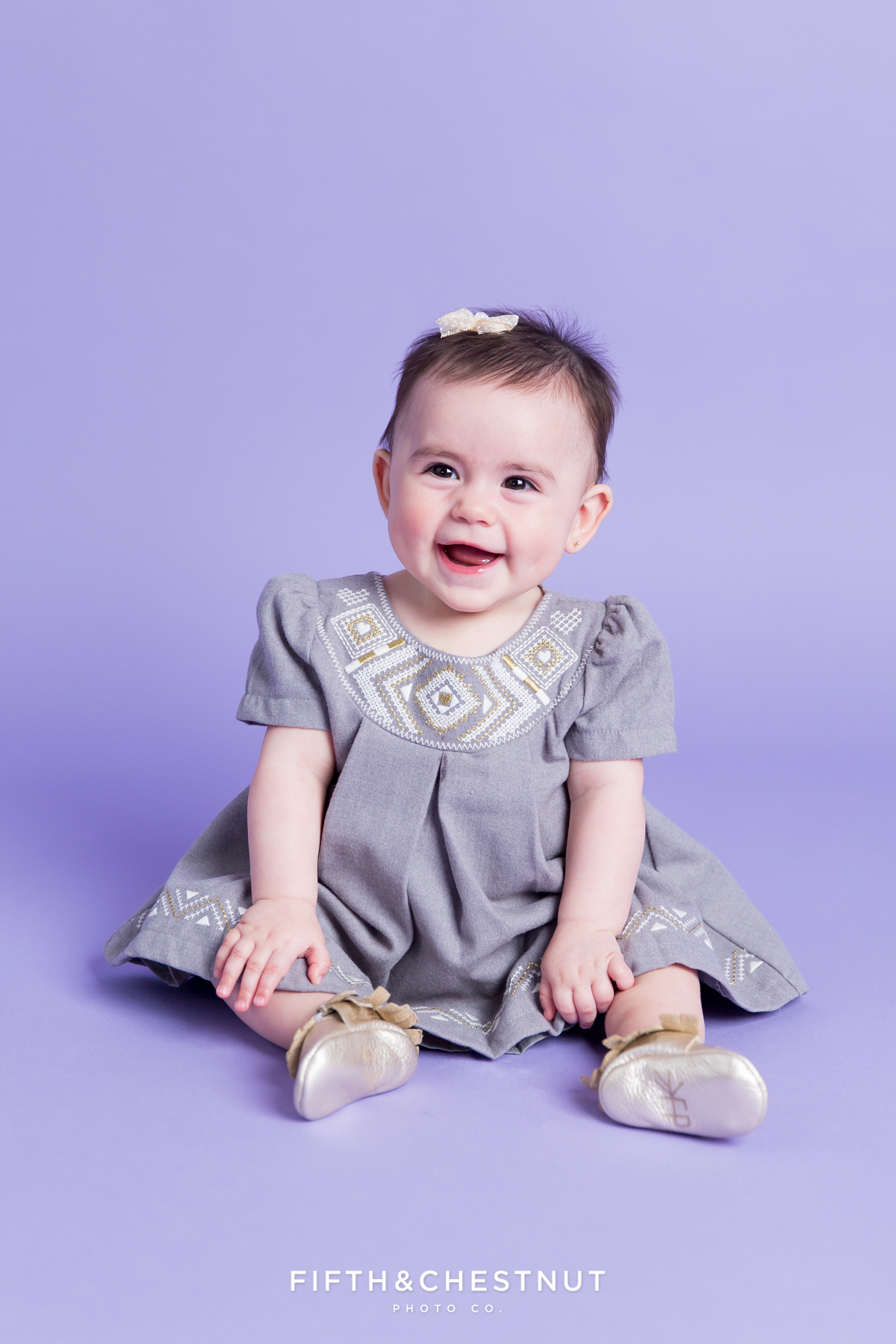 Baby Girl wearing a gray and gold dress for portraits by Reno Baby Photographer Fifth and Chestnut