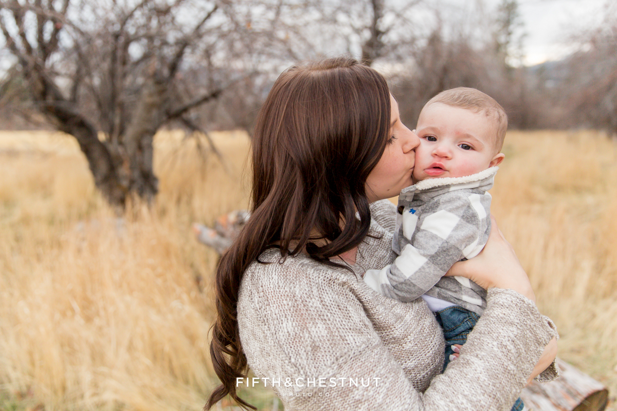A Mom snuggles and kisses her baby boy for mommy and me photos in Reno by Reno Family Photographer