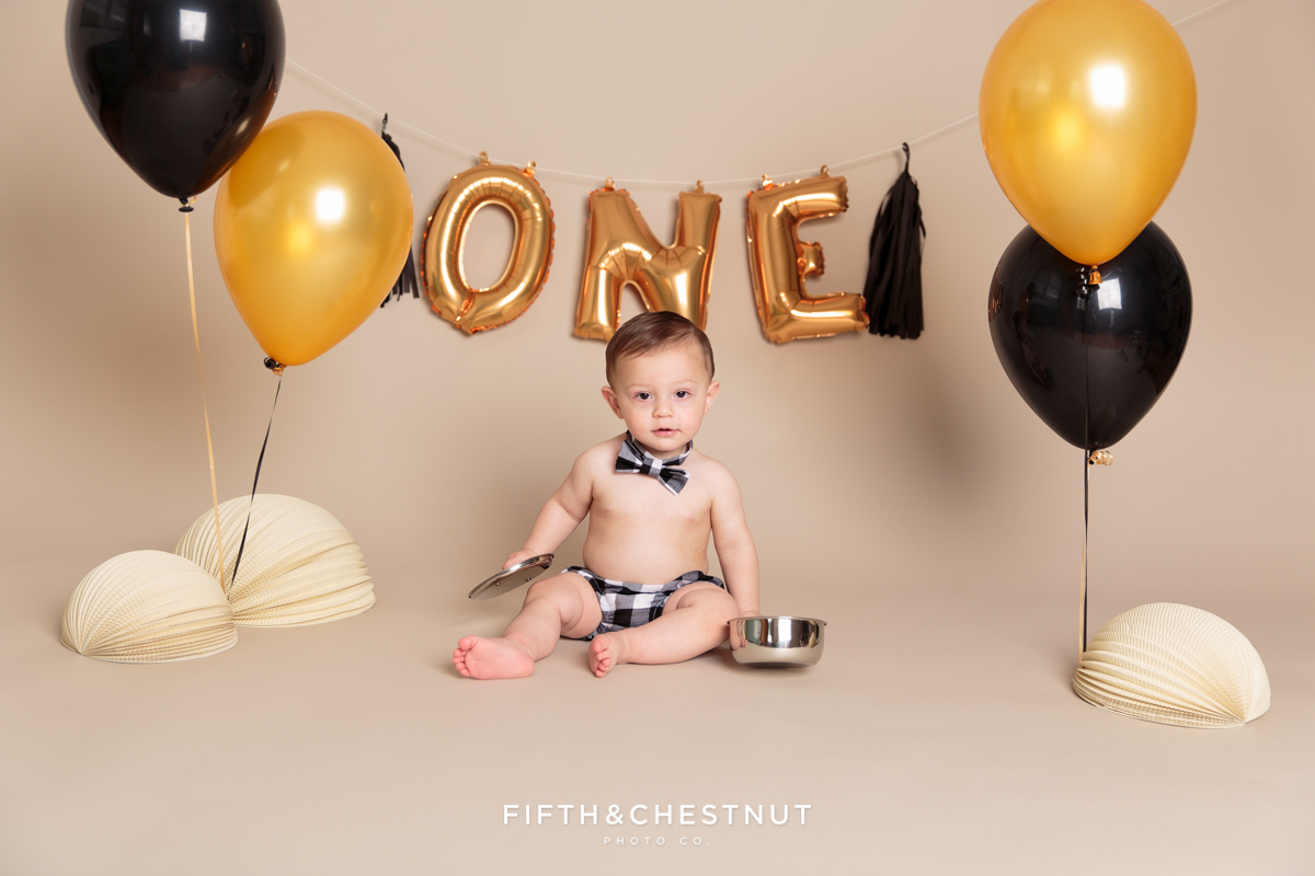 Child posing with pots and pans for his one year spaghetti smash toddler portraits