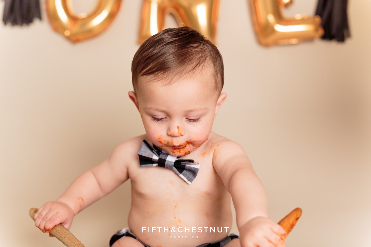 Closeup of baby boy eating spaghetti during his one year spaghetti smash toddler portraits