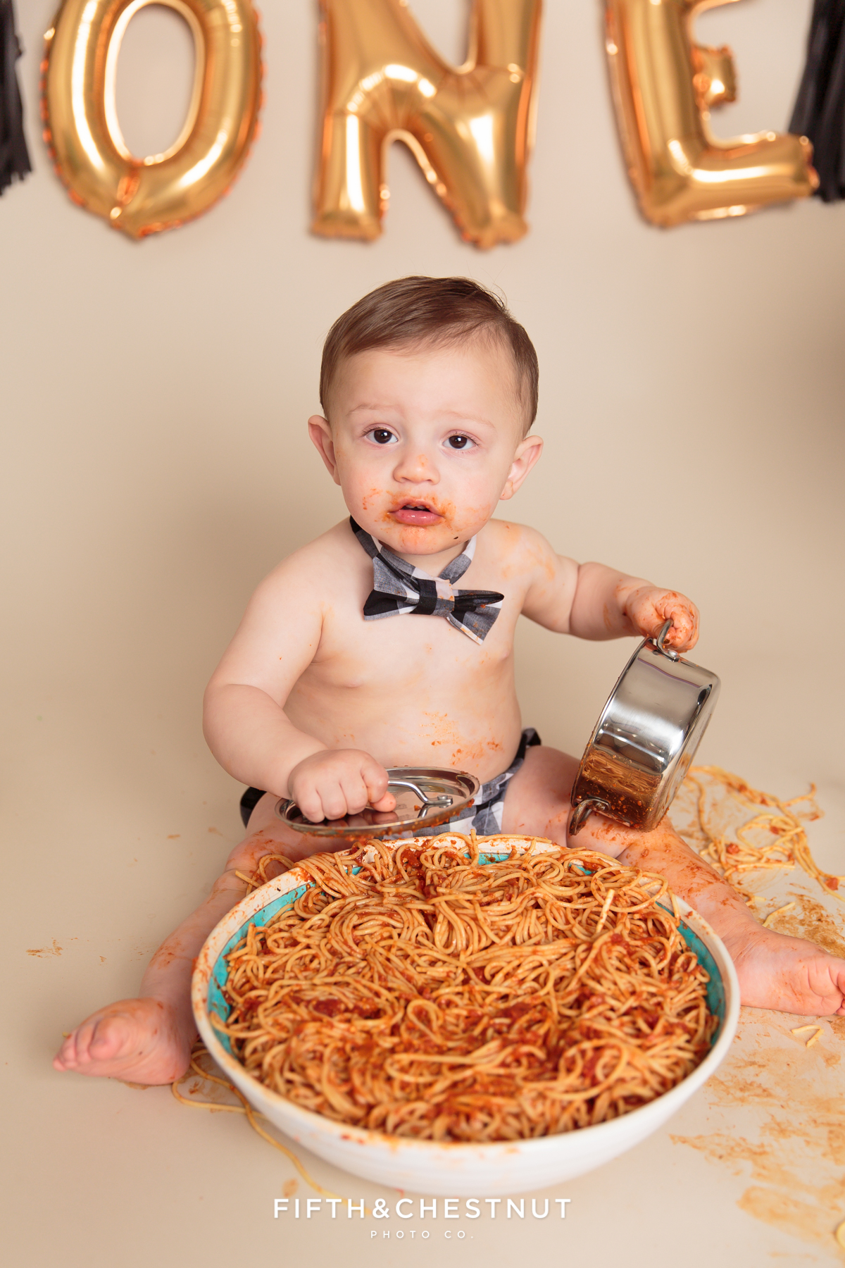 toddler chowing down on spaghetti during his one year spaghetti smash toddler portraits