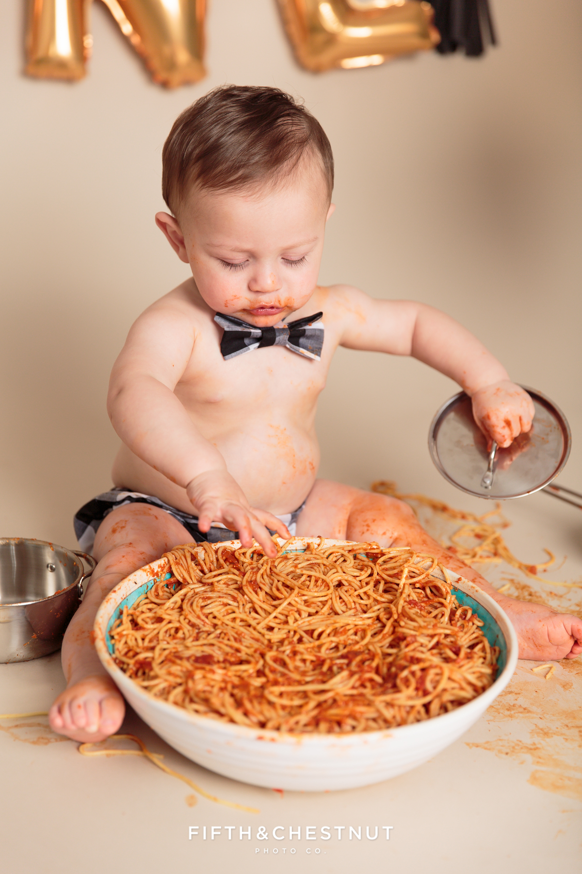 toddler using pots and pans during his one year spaghetti smash toddler portraits