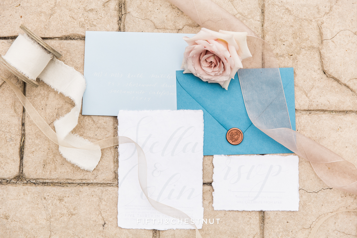 romantic wedding invitation suite and flowers and ribbon for a Dusty Blue Private Estate Country French Wedding Styled Shoot