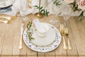 gold flatware and mismatched floral teacups and plates with gold edging for a Dusty Blue Private Estate Country French Wedding Styled Shoot