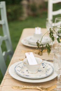 tea cups and plates with gold flatware on vintage dining table for a Dusty Blue Private Estate Country French Wedding Styled Shoot