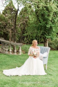 Bride sitting on dusty blue country french chaire at a private estate in Reno, NV
