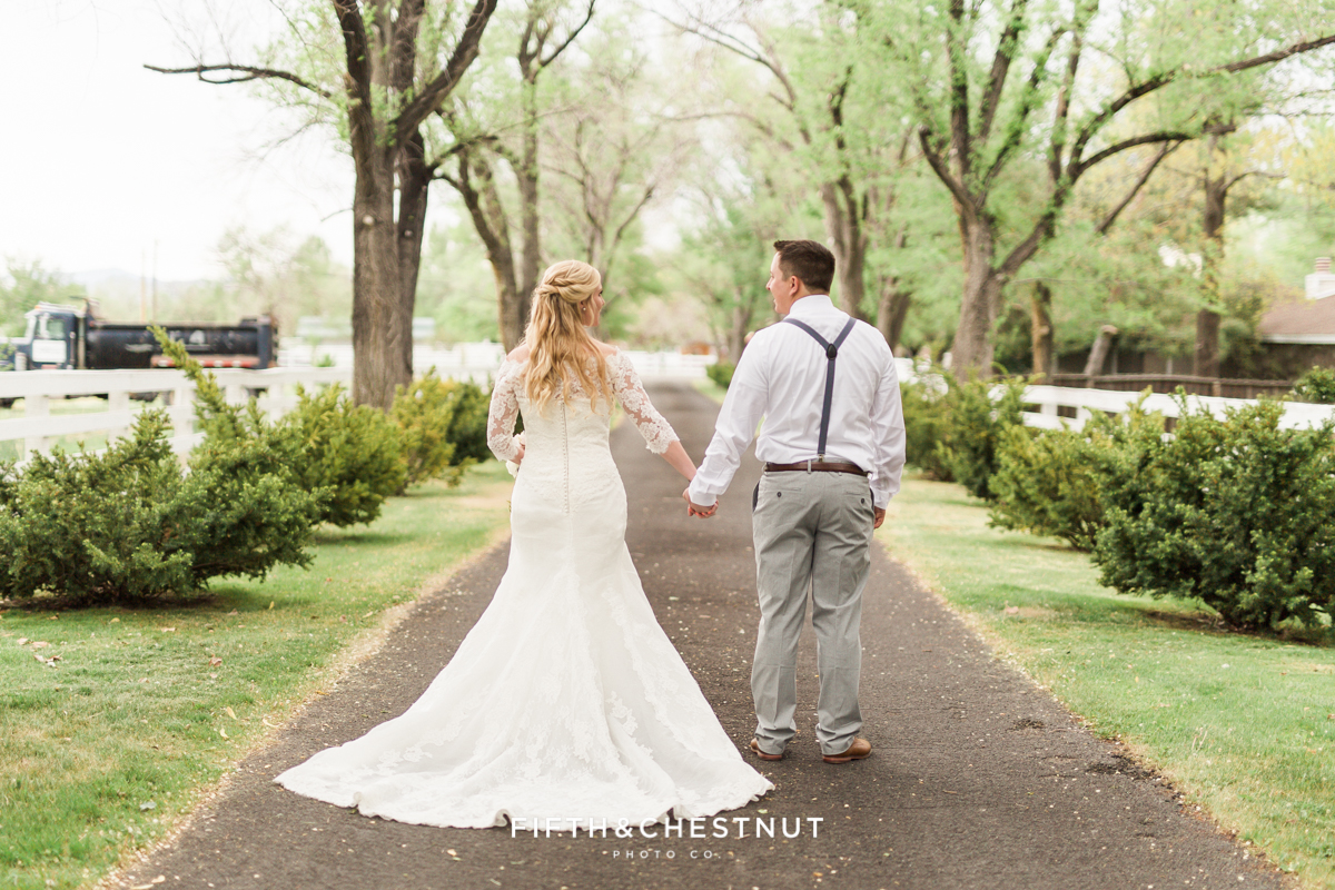 Bride and groom walking down private estate driveway