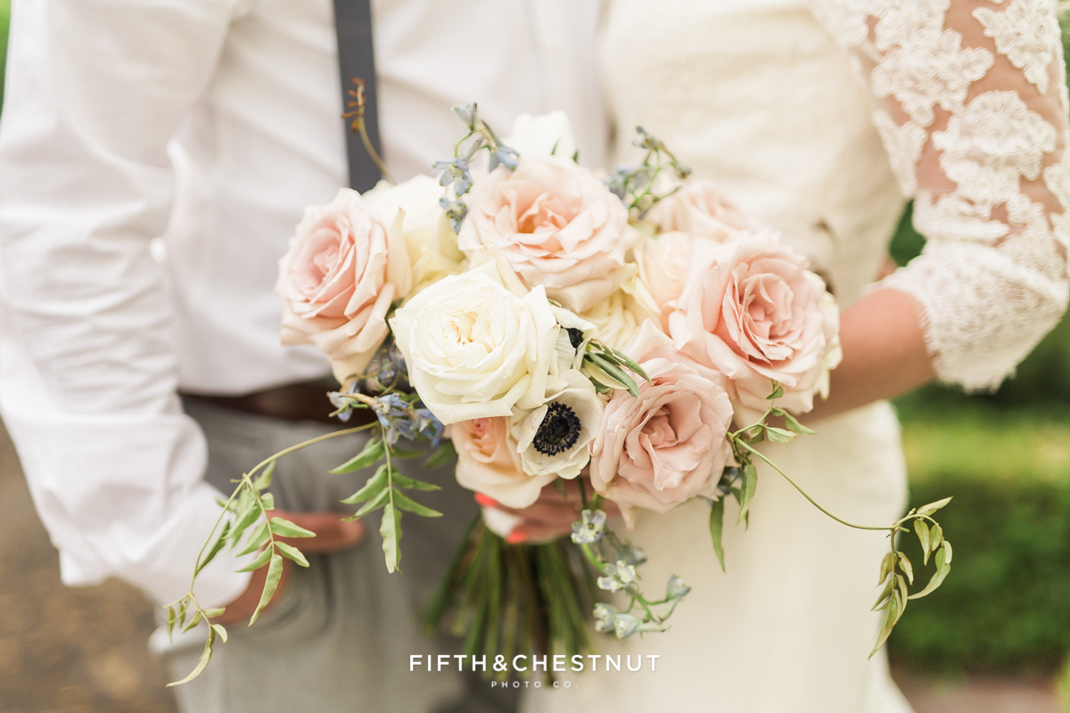 Closeup of country french wedding bouquet as bride stands close to groom