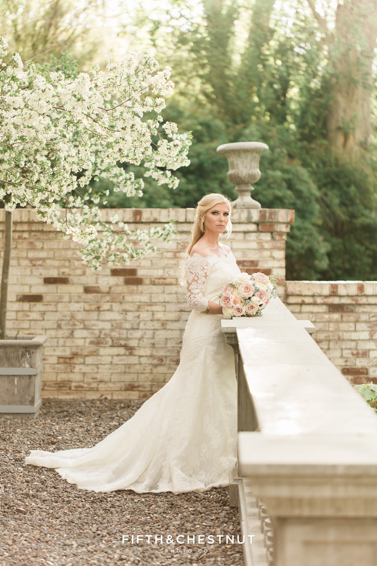 A bride stands on the front porch of a private estate for her country french inspired wedding
