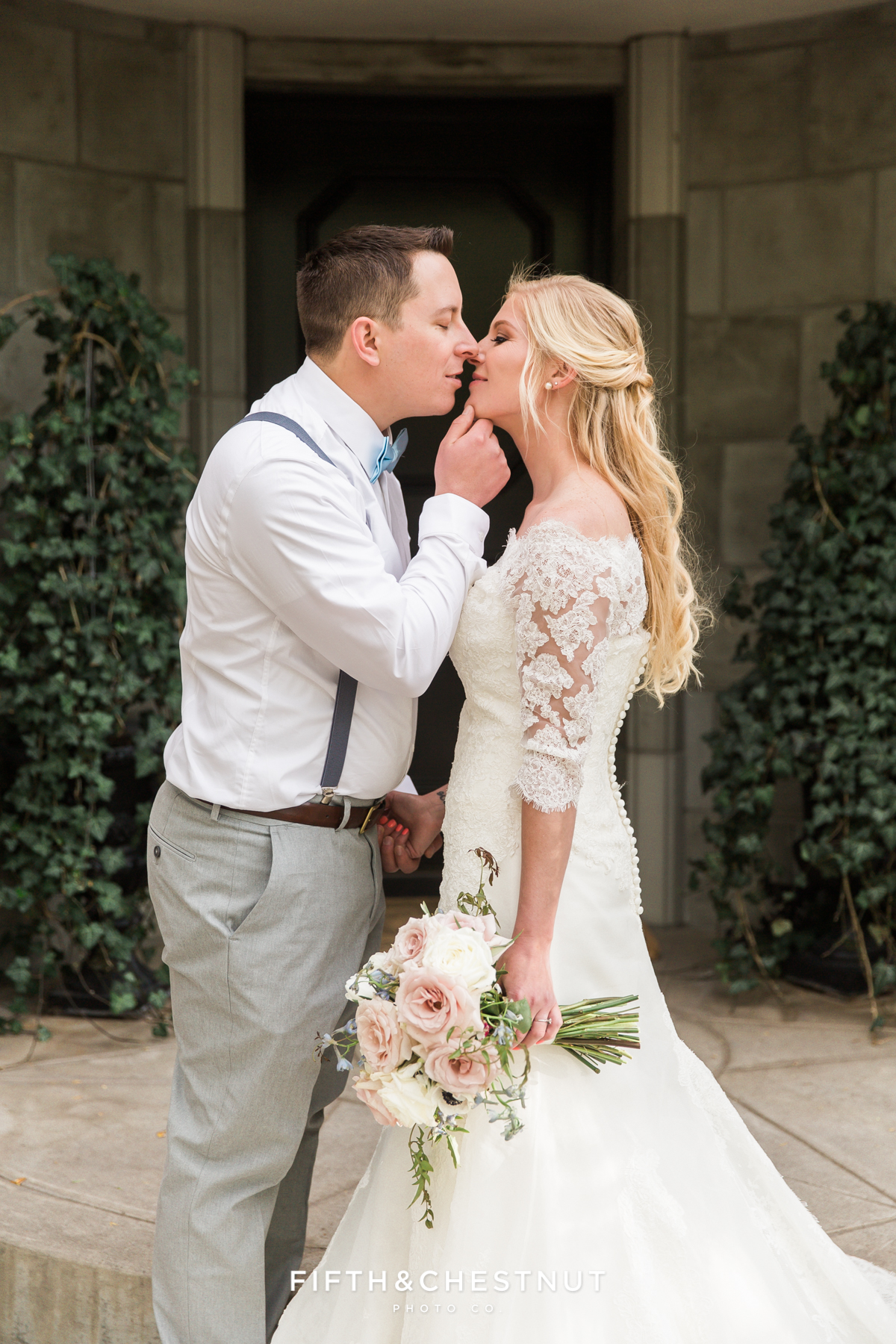 Bride and groom kiss in front of a doorway for a dusty blue private estate country french wedding inspiration styled shoot by Lake Tahoe Wedding photographer