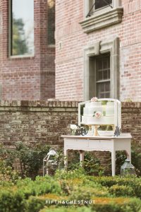 Dusty blue and white ombre watercolor wedding cake on a vintage white vanity table for a dusty blue private estate country french wedding inspiration styled shoot by Lake Tahoe Wedding photographer in front of a brick wall