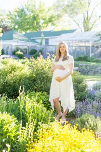 Spring Reno maternity portrait of pregnant woman standing in a beautiful bed of flowers