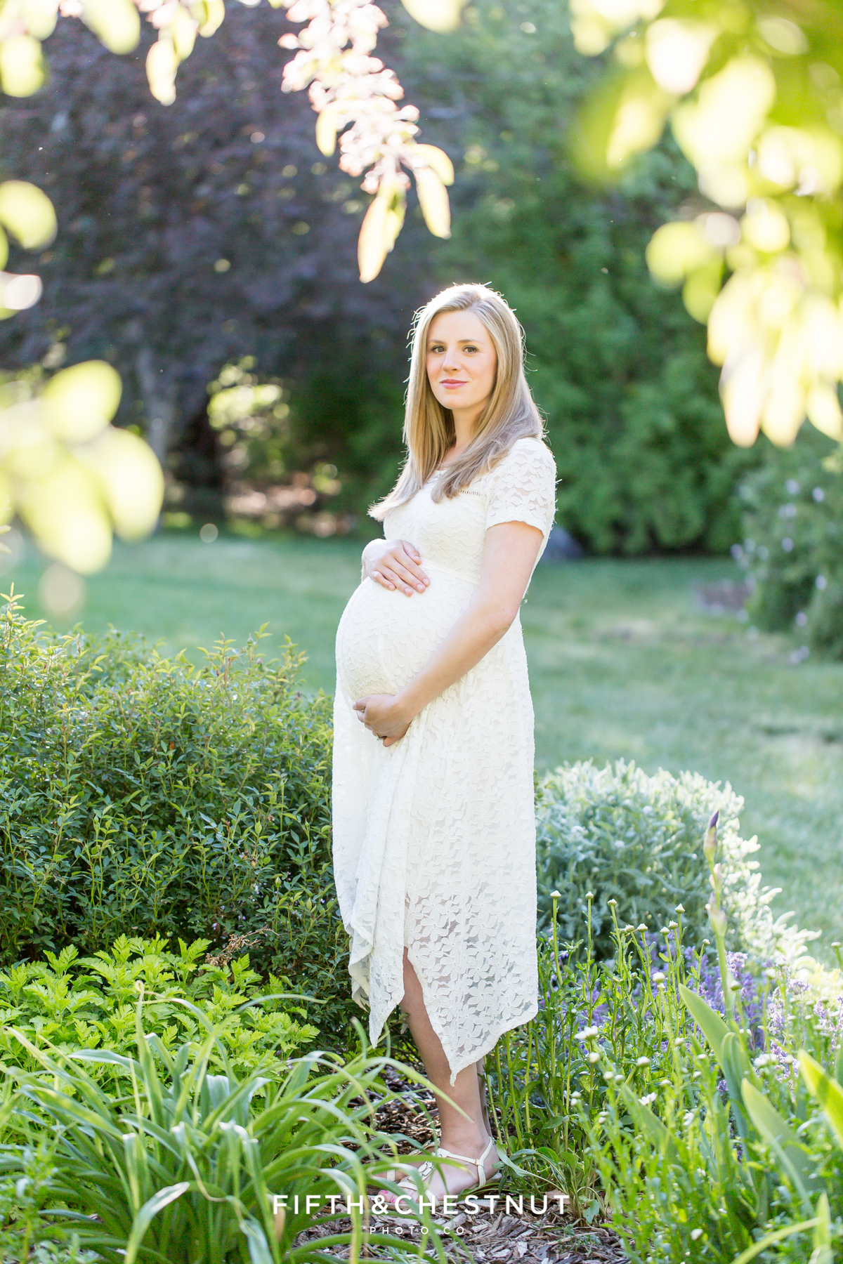 Spring Reno maternity portrait of pregnant woman standing in a bright flower bed by Reno Maternity Photographer