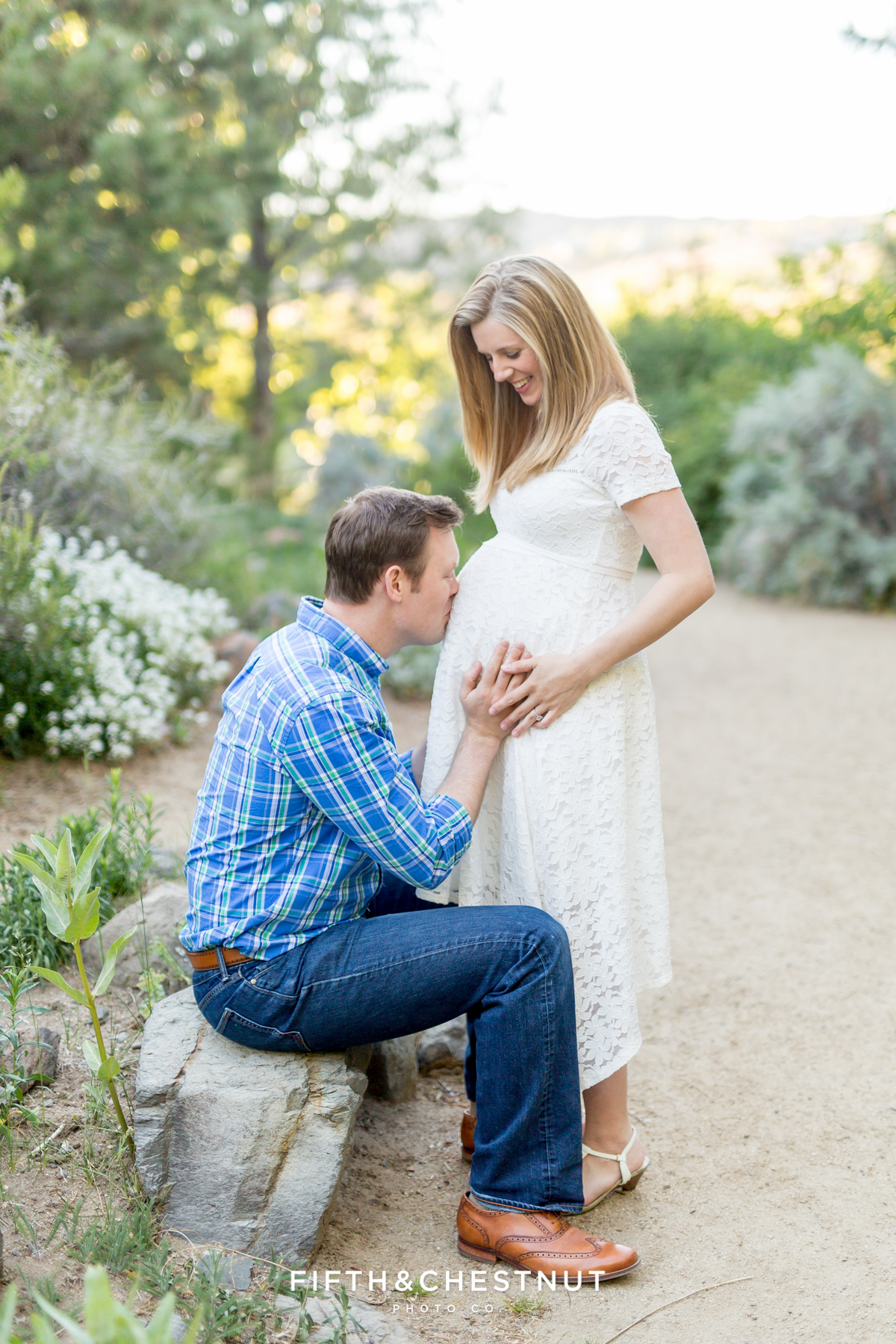 Husband kisses his wife's pregnant belly for spring reno maternity portraits by Reno maternity Photographer