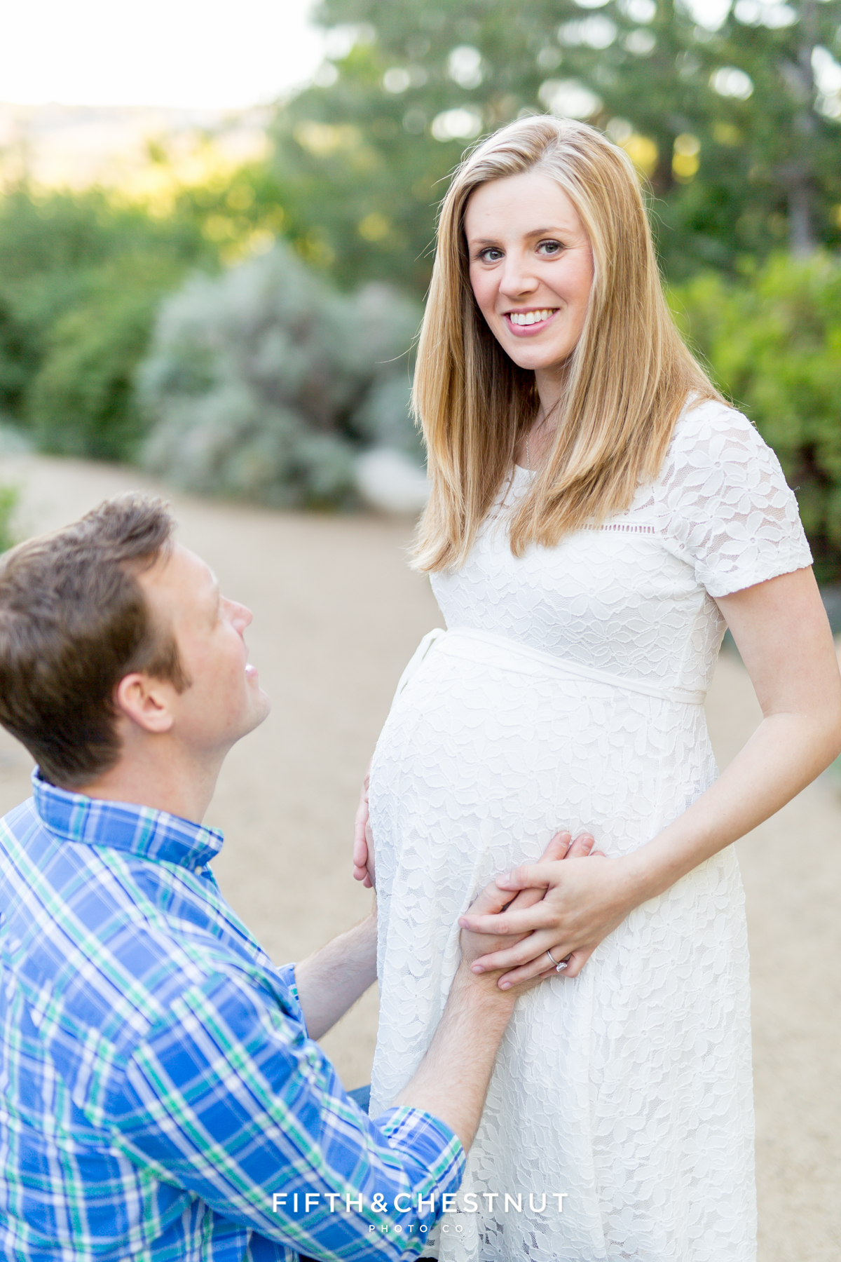 a husband and pregnant wife smile at the camera for a lovely sprintime maternity portrait in Reno