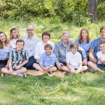 Extended Family Portrait with grandparents and grandchildren sitting in tall green grass in Tahoe Donner area by Truckee Family Photographer