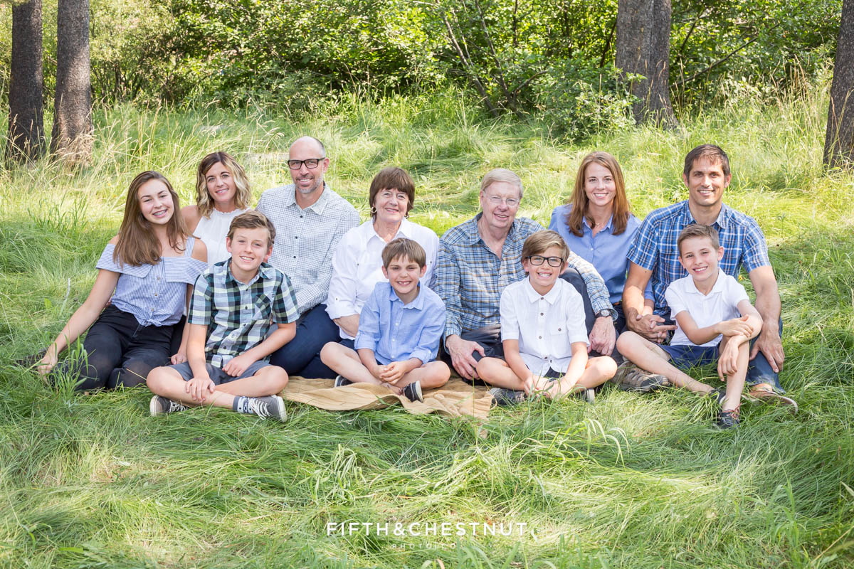 Extended Family Portrait with grandparents and grandchildren sitting in tall green grass in Tahoe Donner area by Truckee Family Photographer