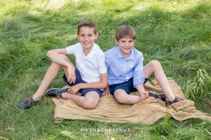 two boys sitting on a blanket laughing together